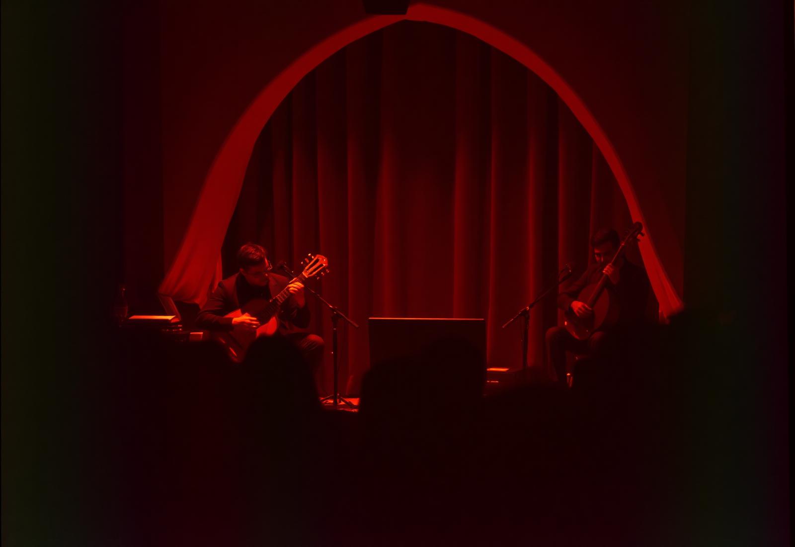 Musicians performing Arabic music live on a warmly lit stage